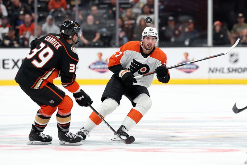 Nov 10, 2023; Anaheim, California, USA; Philadelphia Flyers left wing Noah Cates (27) passes the puck against Anaheim Ducks center Sam Carrick (39) during the first period at Honda Center. Mandatory Credit: Kiyoshi Mio-USA TODAY Sports