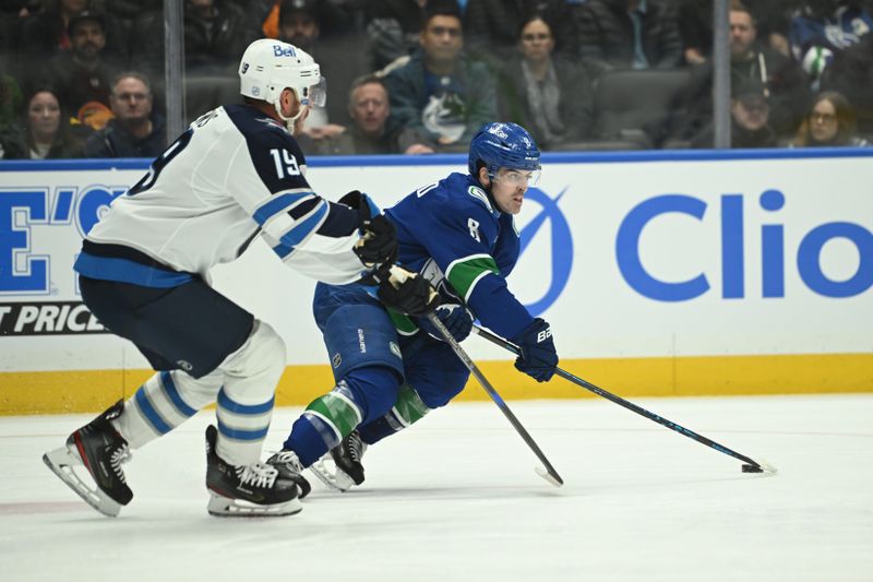 Feb 25, 2026; Vancouver, British Columbia, CAN;  Vancouver Canucks right wing Conor Garland (8) controls the puck against Winnipeg Jets center Jonathan Toews (19) during the third period at Rogers Arena. Mandatory Credit: Simon Fearn-Imagn Images