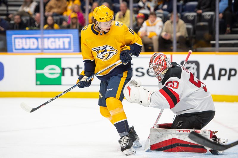 Feb 13, 2024; Nashville, Tennessee, USA;  Nashville Predators center Cody Glass (8) deflects the puck from New Jersey Devils goaltender Nico Daws (50) during the first period at Bridgestone Arena. Mandatory Credit: Steve Roberts-USA TODAY Sports