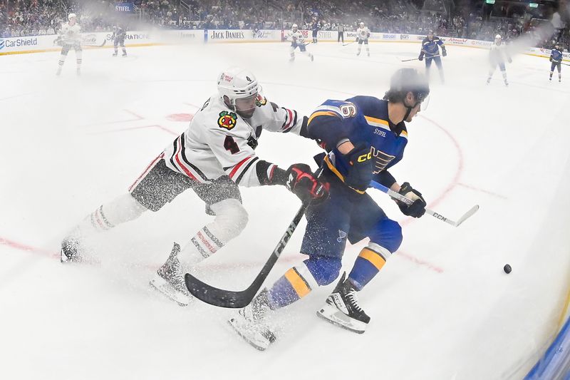 Apr 10, 2024; St. Louis, Missouri, USA;  Chicago Blackhawks defenseman Seth Jones (4) and St. Louis Blues center Zack Bolduc (76) battle for the puck during the second period at Enterprise Center. Mandatory Credit: Jeff Curry-USA TODAY Sports