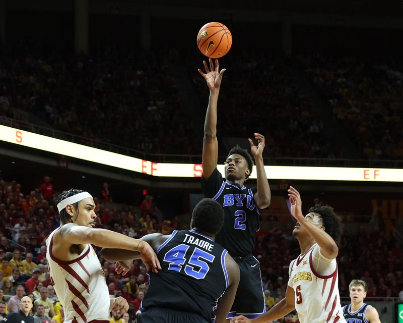 Mar 6, 2024; Ames, Iowa, USA; Brigham Young Cougars guard Jaxson Robinson (2) shoots over Iowa State Cyclones guard Curtis Jones (5) and Iowa State Cyclones forward Robert Jones (12) in the second half at James H. Hilton Coliseum. Mandatory Credit: Reese Strickland-USA TODAY Sports