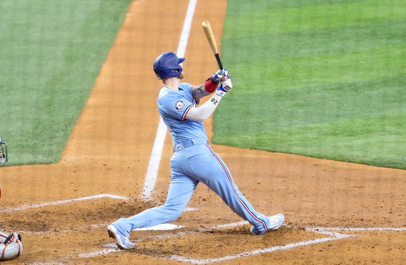 Jul 21, 2024; Arlington, Texas, USA; Texas Rangers catcher Jonah Heim (28) hits a three run home run during the fourth inning against the Baltimore Orioles at Globe Life Field. Mandatory Credit: Kevin Jairaj-USA TODAY Sports