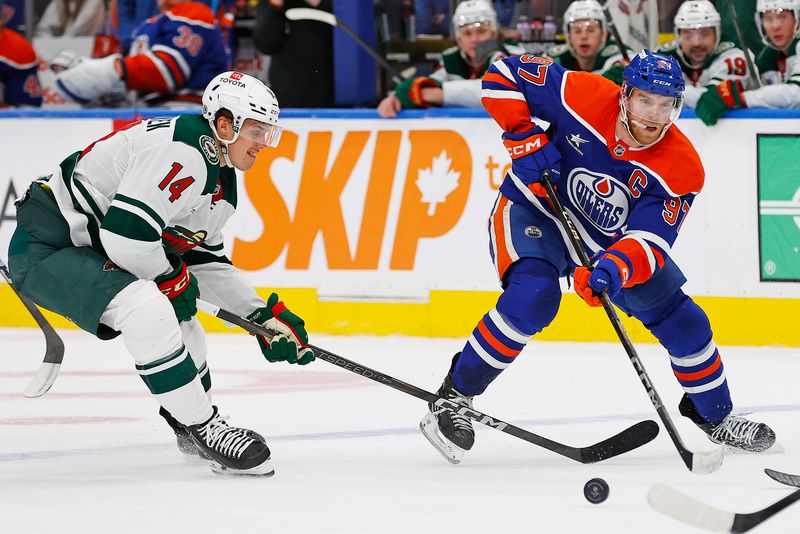 Nov 21, 2024; Edmonton, Alberta, CAN; Edmonton Oilers forward Connor McDavid (97) and Minnesota Wild forward Joel Ericksson EK (14) battle for a loose puck during the third period at Rogers Place. Mandatory Credit: Perry Nelson-Imagn Images