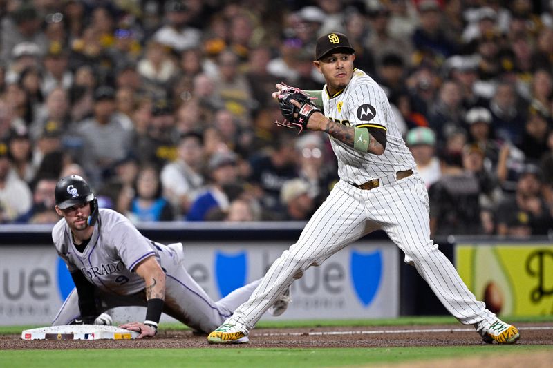 May 13, 2024; San Diego, California, USA; San Diego Padres third baseman Manny Machado (13) looks to throw after Colorado Rockies center fielder Brenton Doyle (9) slid into third base safely during the sixth inning at Petco Park. Mandatory Credit: Orlando Ramirez-USA TODAY Sports