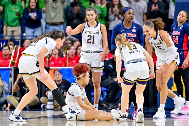 Mar 25, 2024; South Bend, Indiana, USA; Teammates celebrate around Notre Dame Fighting Irish guard Hannah Hidalgo (3) as she sits on the floor after a basket and foul in the first half against the Ole Miss Rebels in the NCAA Tournament second round game at the Purcell Pavilion. Mandatory Credit: Matt Cashore-USA TODAY Sports