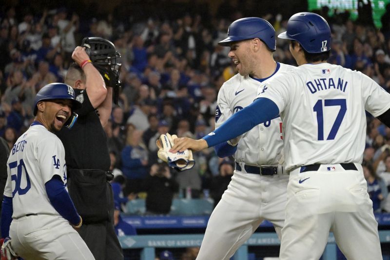 May 20, 2024; Los Angeles, California, USA;  Los Angeles Dodgers first baseman Freddie Freeman (5) is greeted at the plate by shortstop Mookie Betts (50) and designated hitter Shohei Ohtani (17) after hitting a grand slam home run in the third inning against the Arizona Diamondbacks at Dodger Stadium. Mandatory Credit: Jayne Kamin-Oncea-USA TODAY Sports