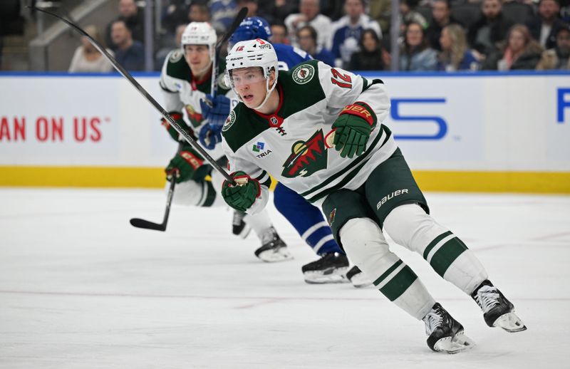 Jan 29, 2025; Toronto, Ontario, CAN;  Minnesota Wild forward Matt Boldy (12) skates against the Toronto Maple Leafs in the second period at Scotiabank Arena. Mandatory Credit: Dan Hamilton-Imagn Images