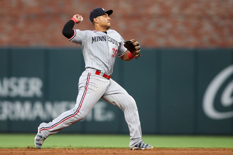 Jun 26, 2023; Atlanta, Georgia, USA; Minnesota Twins second baseman Donovan Solano (39) throws a runner out at first against the Atlanta Braves in the sixth inning at Truist Park. Mandatory Credit: Brett Davis-USA TODAY Sports