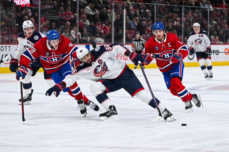 Nov 16, 2024; Montreal, Quebec, CAN; Columbus Blue Jackets right wing Kirill Marchenko (86) attempts to remain in control of the puck as Montreal Canadiens defenseman Lane Hutson (48) defends during the first period at Bell Centre. Mandatory Credit: David Kirouac-Imagn Images