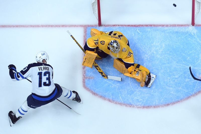 Apr 9, 2024; Nashville, Tennessee, USA; Winnipeg Jets center Gabriel Vilardi (13) scores against Nashville Predators goaltender Juuse Saros (74) during the first period at Bridgestone Arena. Mandatory Credit: Christopher Hanewinckel-USA TODAY Sports