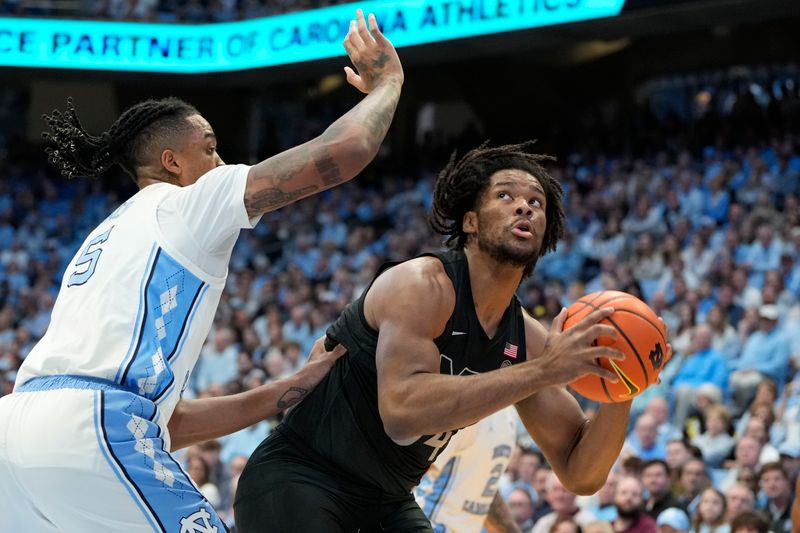 Feb 17, 2024; Chapel Hill, North Carolina, USA; Virginia Tech Hokies forward Mylyjael Poteat (34) with the ball as North Carolina Tar Heels forward Armando Bacot (5) defends in the first half at Dean E. Smith Center. Mandatory Credit: Bob Donnan-USA TODAY Sports