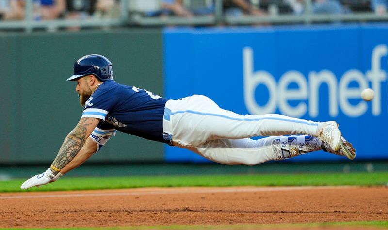 May 9, 2025; Kansas City, Missouri, USA; Kansas City Royals center fielder Kyle Isbel (28) dives into third base for a triple during the fifth inning against the Boston Red Sox at Kauffman Stadium. Mandatory Credit: Jay Biggerstaff-Imagn Images