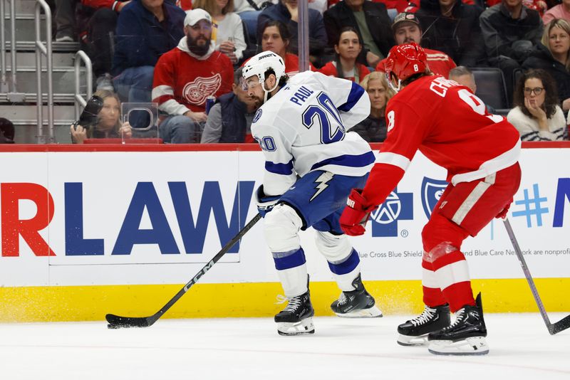 Jan 25, 2025; Detroit, Michigan, USA;  Tampa Bay Lightning left wing Nick Paul (20) skates with the puck defended by Detroit Red Wings defenseman Ben Chiarot (8) in the third period at Little Caesars Arena. Mandatory Credit: Rick Osentoski-Imagn Images