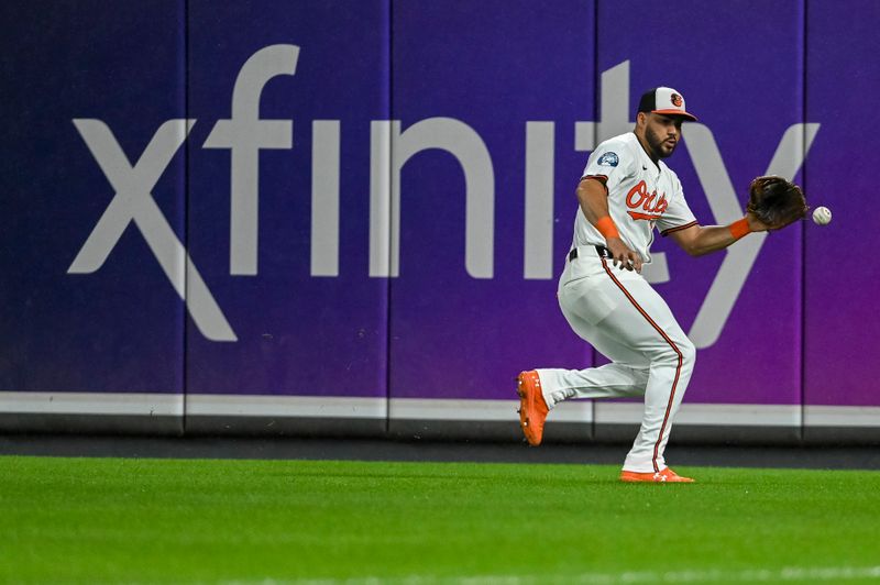 Sep 17, 2024; Baltimore, Maryland, USA;  Baltimore Orioles outfielder Anthony Santander (25) fields San Francisco Giants outfielder Grant McCray (58) fourth inning single at Oriole Park at Camden Yards. Mandatory Credit: Tommy Gilligan-Imagn Images