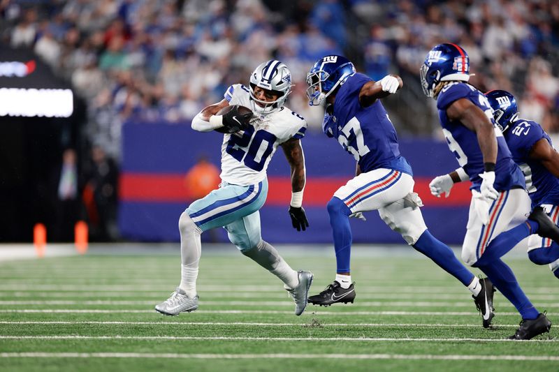 Dallas Cowboys' Tony Pollard, left, runs the ball during the second half of an NFL football game against the New York Giants, Sunday, Sept. 10, 2023, in East Rutherford, N.J. (AP Photo/Adam Hunger)