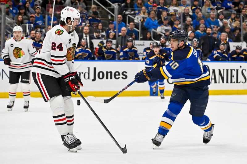 Apr 10, 2024; St. Louis, Missouri, USA;  St. Louis Blues center Brayden Schenn (10) shoots as Chicago Blackhawks defenseman Jaycob Megna (24) defends during the second period at Enterprise Center. Mandatory Credit: Jeff Curry-USA TODAY Sports