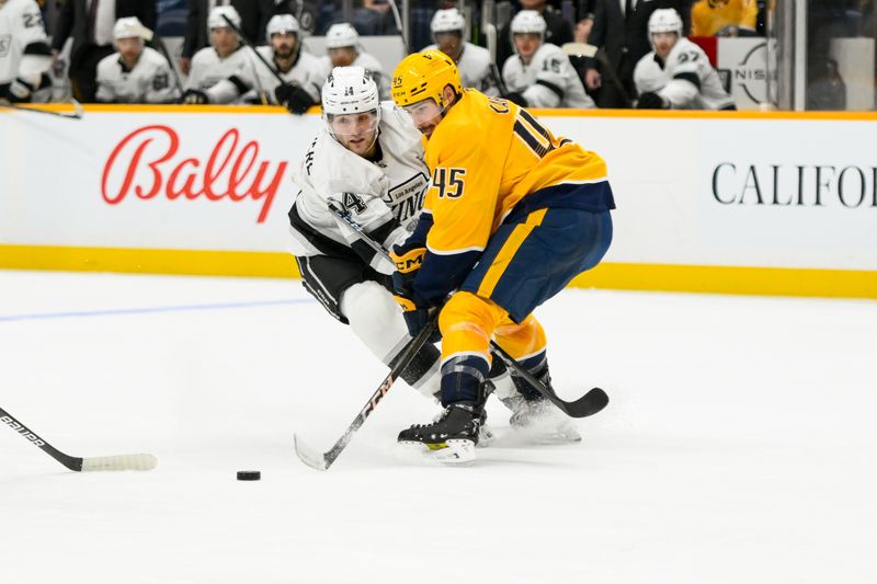 Nov 4, 2024; Nashville, Tennessee, USA;  Nashville Predators defenseman Alexandre Carrier (45) and Los Angeles Kings right wing Alex Laferriere (14) fight for the puck during the second period at Bridgestone Arena. Mandatory Credit: Steve Roberts-Imagn Images