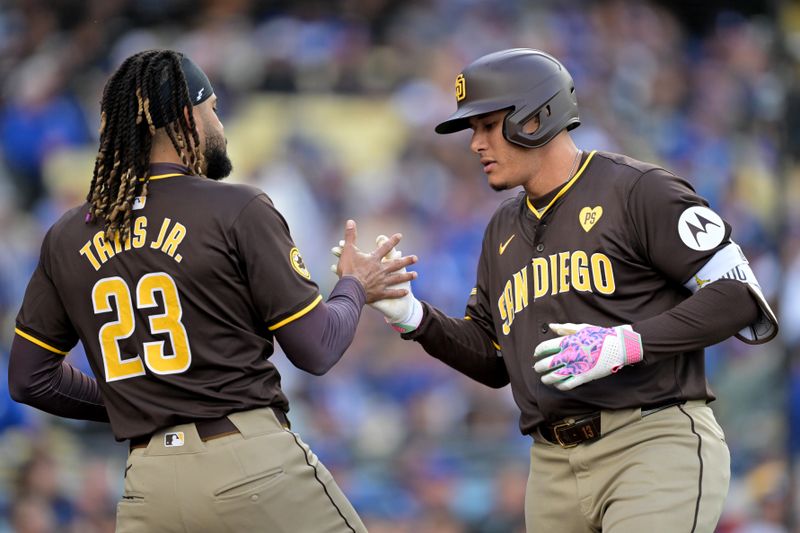 Apr 14, 2024; Los Angeles, California, USA; San Diego Padres third base Manny Machado (13) is congratulated by outfielder Fernando Tatis Jr. (23) after hitting a solo home run in the fourth inning against the Los Angeles Dodgers at Dodger Stadium. Mandatory Credit: Jayne Kamin-Oncea-USA TODAY Sports