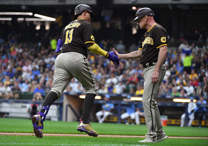 Aug 25, 2023; Milwaukee, Wisconsin, USA; San Diego Padres third base coach & infield instructor Matt Williams (18) congratulates San Diego Padres third baseman Manny Machado (13) after hitting a home run in the fourth inning against the Milwaukee Brewers at American Family Field. Mandatory Credit: Michael McLoone-USA TODAY Sports