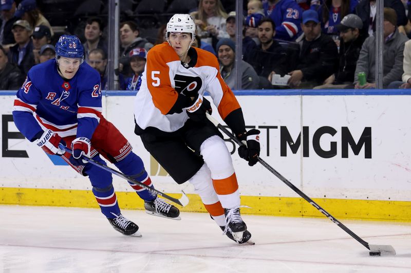 Mar 26, 2024; New York, New York, USA; Philadelphia Flyers defenseman Egor Zamula (5) skates with the puck against New York Rangers right wing Kaapo Kakko (24) during the first period at Madison Square Garden. Mandatory Credit: Brad Penner-USA TODAY Sports