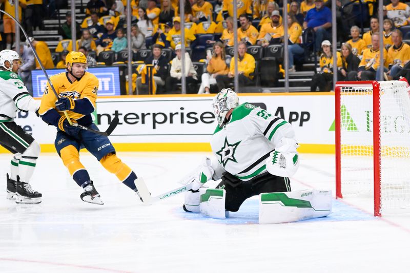 Oct 10, 2024; Nashville, Tennessee, USA;  Dallas Stars goaltender Jake Oettinger (29) blocks the shot of Nashville Predators left wing Cole Smith (36) during the first period at Bridgestone Arena. Mandatory Credit: Steve Roberts-Imagn Images