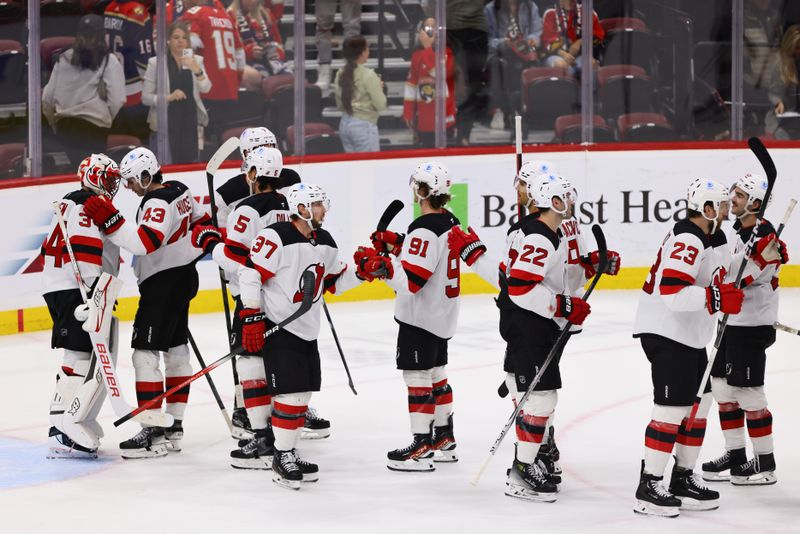 Nov 14, 2024; Sunrise, Florida, USA; New Jersey Devils players celebrate after the game against the Florida Panthers at Amerant Bank Arena. Mandatory Credit: Sam Navarro-Imagn Images