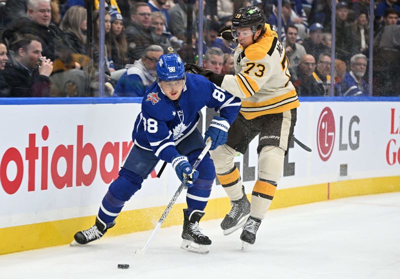 Dec 2, 2023; Toronto, Ontario, CAN; Toronto Maple Leafs forward William Nylander (88) moves the puck away from Boston Bruins defenseman Charlie McAvoy (73) in the first  period at Scotiabank Arena. Mandatory Credit: Dan Hamilton-USA TODAY Sports