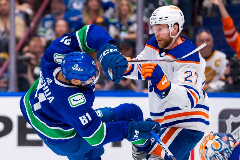 May 10, 2024; Vancouver, British Columbia, CAN; Edmonton Oilers defenseman Brett Kulak (27) checks Vancouver Canucks forward Dakota Joshua (81) during the third period in game two of the second round of the 2024 Stanley Cup Playoffs at Rogers Arena. Mandatory Credit: Bob Frid-USA TODAY Sports