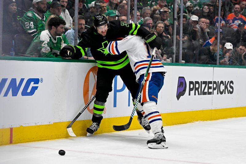 Apr 3, 2024; Dallas, Texas, USA; Edmonton Oilers left wing Zach Hyman (18) checks Dallas Stars defenseman Chris Tanev (3) as they battle for control of the puck during the third period at the American Airlines Center. Mandatory Credit: Jerome Miron-USA TODAY Sports