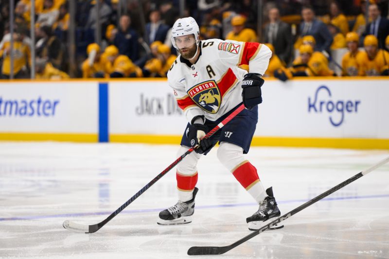 Feb 25, 2025; Nashville, Tennessee, USA;  Florida Panthers defenseman Aaron Ekblad (5) skates with the puck against the Nashville Predators during the second period at Bridgestone Arena. Mandatory Credit: Steve Roberts-Imagn Images