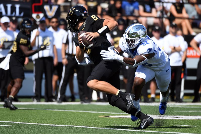 Sep 23, 2023; Nashville, Tennessee, USA; Vanderbilt Commodores quarterback AJ Swann (5) scrambles away from Kentucky Wildcats linebacker Trevin Wallace (32) during the first half at FirstBank Stadium. Mandatory Credit: Christopher Hanewinckel-USA TODAY Sports