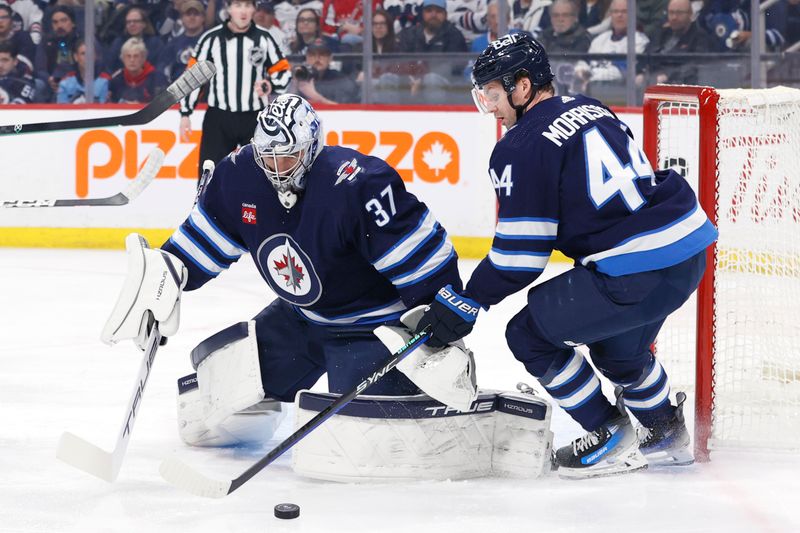 Mar 11, 2024; Winnipeg, Manitoba, CAN; Winnipeg Jets defenseman Josh Morrissey (44) gets a rebound in front of  goaltender Connor Hellebuyck (37) in the first period against the Washington Capitals at Canada Life Centre. Mandatory Credit: James Carey Lauder-USA TODAY Sports