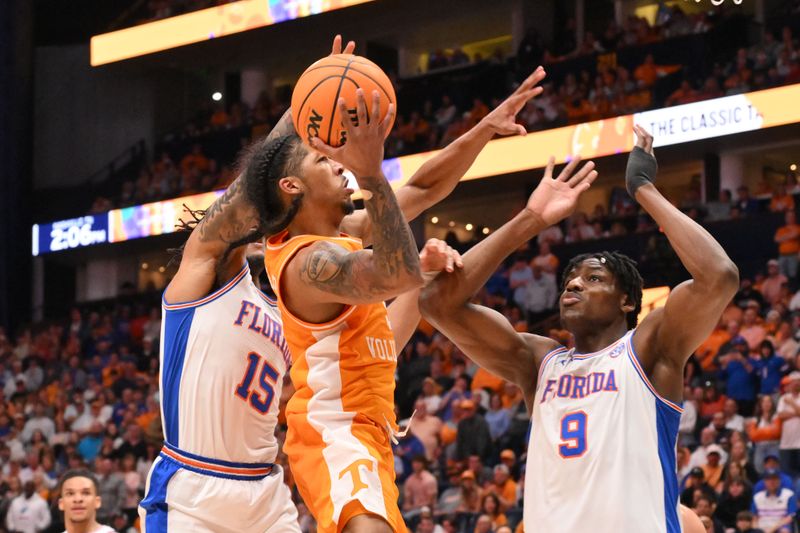 Mar 16, 2025; Nashville, TN, USA; Tennessee Volunteers guard Zakai Zeigler (5) shoots the ball against Florida Gators guard Alijah Martin (15) and center Rueben Chinyelu (9) in the second half during the 2025 SEC Championship Game at Bridgestone Arena. Mandatory Credit: Steve Roberts-Imagn Images