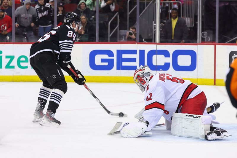 Mar 9, 2024; Newark, New Jersey, USA; New Jersey Devils center Jack Hughes (86) skates with the puck while Carolina Hurricanes goaltender Pyotr Kochetkov (52) defends his net during the second period at Prudential Center. Mandatory Credit: Ed Mulholland-USA TODAY Sports