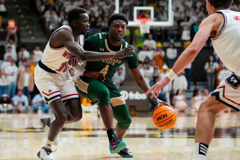 Jan 27, 2024; Laramie, Wyoming, USA; Colorado State Rams forward Isaiah Stevens (4) controls the ball against Wyoming Cowboys guard Akuel Kot (13) during the first half at Arena-Auditorium. Mandatory Credit: Troy Babbitt-USA TODAY Sports