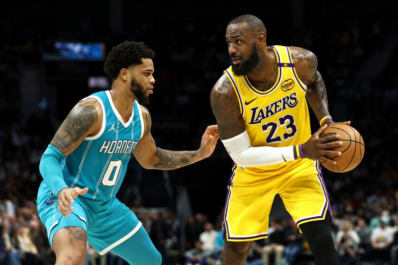 CHARLOTTE, NORTH CAROLINA - JANUARY 27: LeBron James #23 of the Los Angeles Lakers is defended by Miles Bridges #0 of the Charlotte Hornets during the first half of the game at Spectrum Center on January 27, 2025 in Charlotte, North Carolina. NOTE TO USER: User expressly acknowledges and agrees that, by downloading and or using this photograph, User is consenting to the terms and conditions of the Getty Images License Agreement. (Photo by Jared C. Tilton/Getty Images)