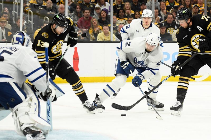 May 4, 2024; Boston, Massachusetts, USA; Boston Bruins defenseman Charlie McAvoy (73) tries to control the puck while Toronto Maple Leafs defenseman Simon Benoit (2) defends during the third period in game seven of the first round of the 2024 Stanley Cup Playoffs at TD Garden. Mandatory Credit: Bob DeChiara-USA TODAY Sports