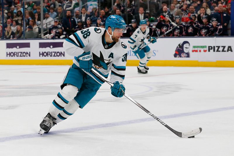 Mar 16, 2024; Columbus, Ohio, USA; San Jose Sharks defenseman Mario Ferraro (38) carries the puck against the Columbus Blue Jackets during the second period at Nationwide Arena. Mandatory Credit: Russell LaBounty-USA TODAY Sports