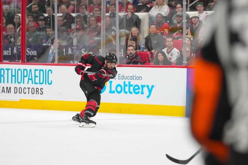 Feb 26, 2026; Raleigh, North Carolina, USA;  Carolina Hurricanes defenseman Shayne Gostisbehere (4) takes a shot against the Tampa Bay Lightning during the first period at Lenovo Center. Mandatory Credit: James Guillory-Imagn Images