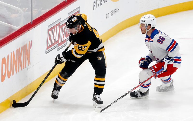 Mar 16, 2024; Pittsburgh, Pennsylvania, USA;  Pittsburgh Penguins center Sidney Crosby (87) moves the puck against New York Rangers center Jack Roslovic (96) during the third period at PPG Paints Arena. New York won 7-4. Mandatory Credit: Charles LeClaire-USA TODAY Sports