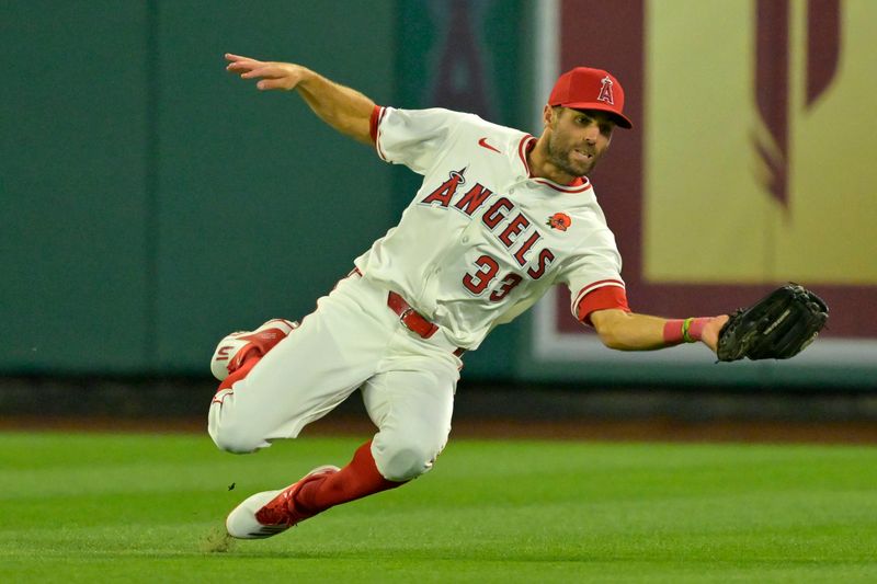 May 26, 2025; Anaheim, California, USA;  Los Angeles Angels center fielder Chris Taylor (33) makes a running catch off a ball hit by New York Yankees third baseman Oswald Peraza (18) in the eighth inning at Angel Stadium. Mandatory Credit: Jayne Kamin-Oncea-Imagn Images