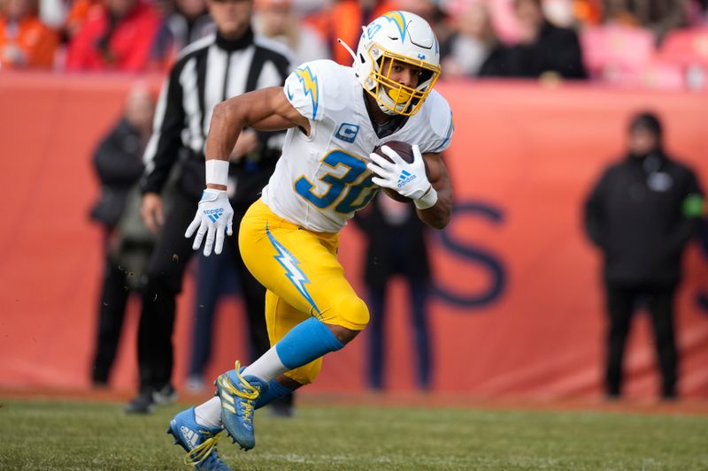 Los Angeles Chargers running back Austin Ekeler (30) runs against the Denver Broncos during the first half of an NFL football game, Sunday, Dec. 31, 2023, in Denver. (AP Photo/David Zalubowski)