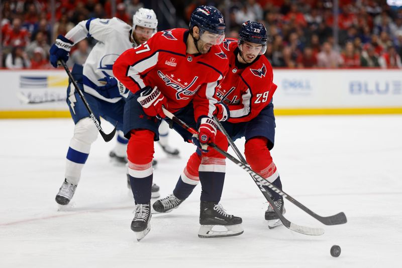 Apr 13, 2024; Washington, District of Columbia, USA; Washington Capitals left wing Max Pacioretty (67) and Capitals center Hendrix Lapierre (29) reach for the puck in front of Tampa Bay Lightning defenseman Victor Hedman (77) in the third period at Capital One Arena. Mandatory Credit: Geoff Burke-USA TODAY Sports