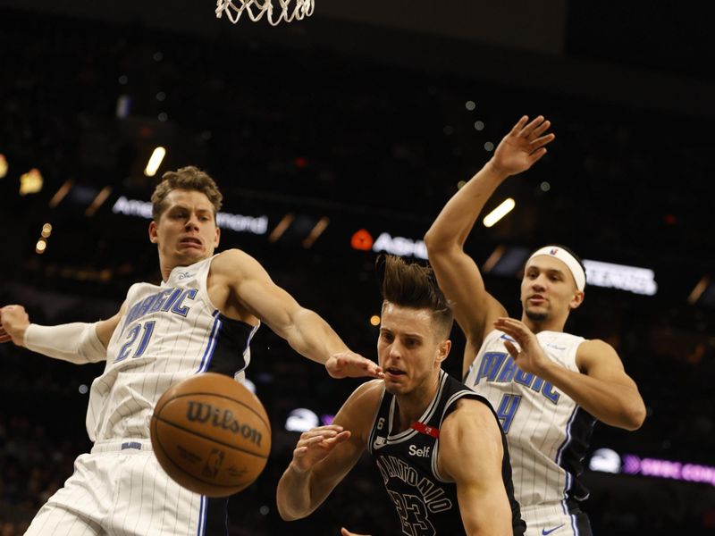 SAN ANTONIO, TX - MARCH 14: Zach Collins #23 of the San Antonio Spurs dives for a loose ball past Moritz Wagner #21 and Jalen Suggs #4 of the Orlando Magic in the first half at AT&T Center on March 14, 2023 in San Antonio, Texas. NOTE TO USER: User expressly acknowledges and agrees that, by downloading and or using this photograph, User is consenting to terms and conditions of the Getty Images License Agreement. (Photo by Ronald Cortes/Getty Images)