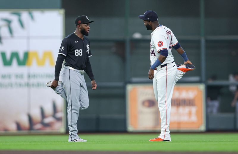 Aug 17, 2024; Houston, Texas, USA; Chicago White Sox center fielder Luis Robert Jr. (88) and Houston Astros left fielder Yordan Alvarez (44) talk on the field while stretching before the game at Minute Maid Park. Mandatory Credit: Troy Taormina-USA TODAY Sports