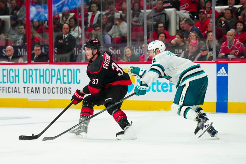 Oct 27, 2023; Raleigh, North Carolina, USA; Carolina Hurricanes right wing Andrei Svechnikov (37) skates with the puck against San Jose Sharks defenseman Ty Emberson (6) during the third period at PNC Arena. Mandatory Credit: James Guillory-USA TODAY Sports