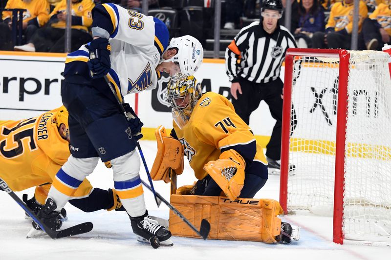 Apr 4, 2024; Nashville, Tennessee, USA; Nashville Predators goaltender Juuse Saros (74) makes a save on a shot by St. Louis Blues left wing Jake Neighbours (63) during the second period at Bridgestone Arena. Mandatory Credit: Christopher Hanewinckel-USA TODAY Sports