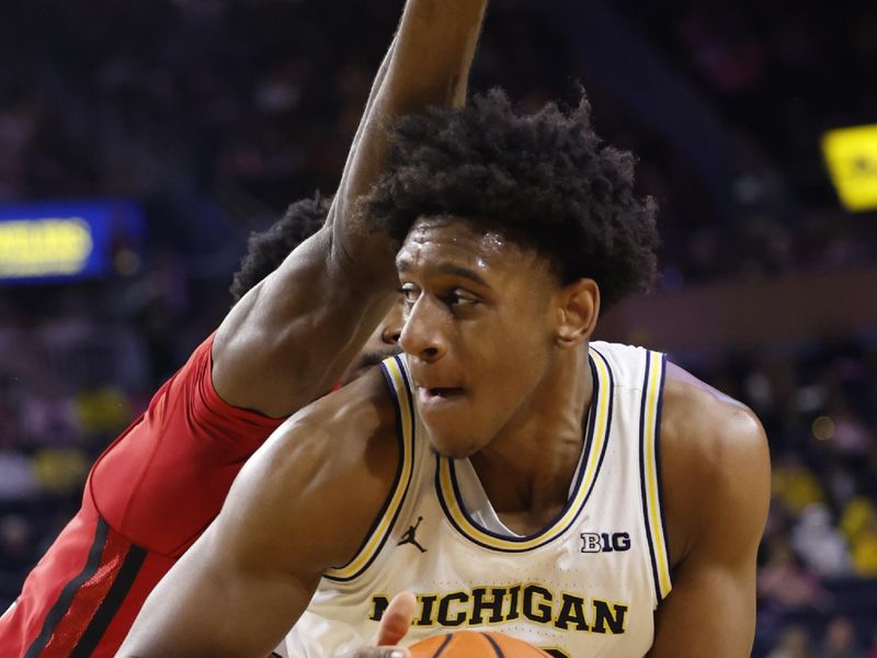 Feb 3, 2024; Ann Arbor, Michigan, USA;  Michigan Wolverines forward Tarris Reed Jr. (32) is defended by Rutgers Scarlet Knights center Emmanuel Ogbole (22) in the first half at Crisler Center. Mandatory Credit: Rick Osentoski-USA TODAY Sports