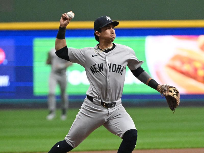 Apr 28, 2024; Milwaukee, Wisconsin, USA; New York Yankees third base Oswaldo Cabrera (95) gets the force out at third and throws to first against the Milwaukee Brewers win the second inning at American Family Field. Mandatory Credit: Michael McLoone-USA TODAY Sports