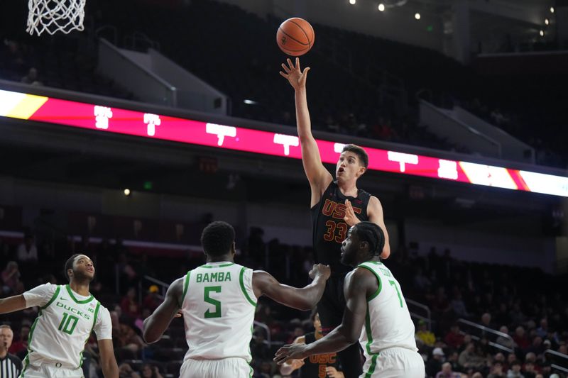 Dec 4, 2024; Los Angeles, California, USA; Southern California Trojans forward Josh Cohen (33) shoots the ball against Oregon Ducks forward Supreme Cook (7), guard TJ Bamba (5) and forward Kwame Evans Jr. (10) in the first half at Galen Center. Mandatory Credit: Kirby Lee-Imagn ImagesDec 4, 2024; Los Angeles, California, USA; at Galen Center. Mandatory Credit: Kirby Lee-Imagn Images